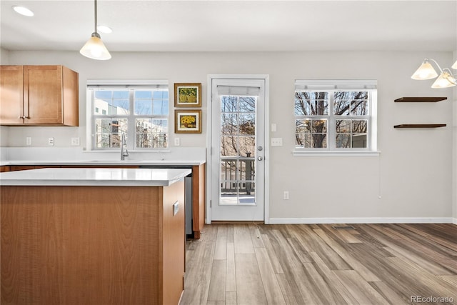 kitchen with sink, hanging light fixtures, and light hardwood / wood-style flooring