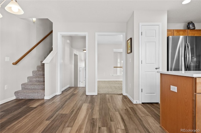 kitchen with dark hardwood / wood-style floors, stainless steel fridge, and decorative light fixtures