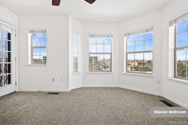 carpeted spare room featuring ceiling fan