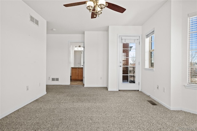 carpeted spare room featuring ceiling fan