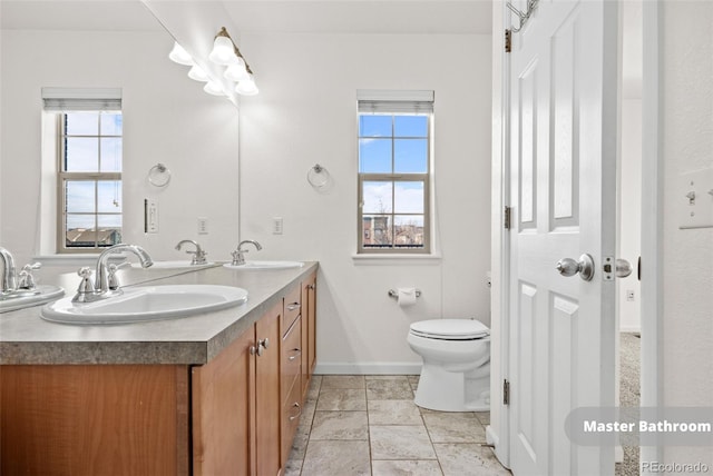 bathroom with vanity, a healthy amount of sunlight, and toilet