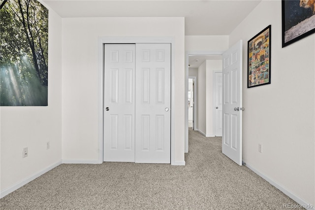 unfurnished bedroom featuring light carpet and a closet