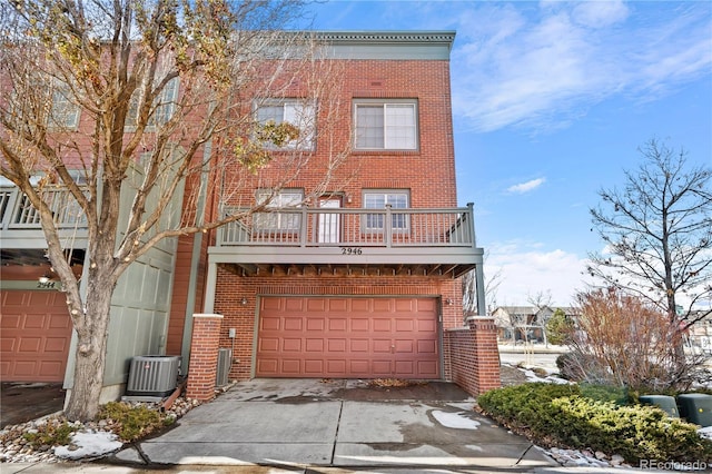 townhome / multi-family property with a garage, a balcony, and central air condition unit