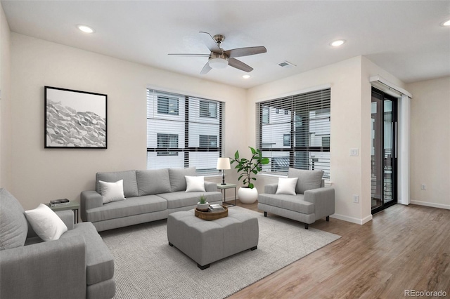 living room featuring a ceiling fan, recessed lighting, baseboards, visible vents, and wood finished floors