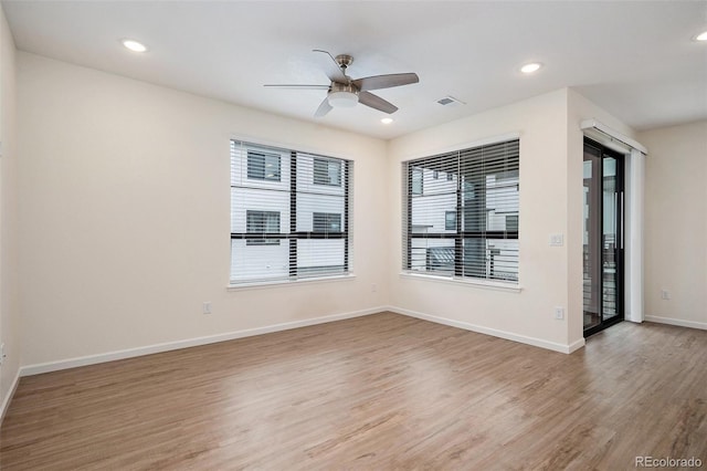unfurnished room with light wood-style flooring, a ceiling fan, visible vents, baseboards, and recessed lighting
