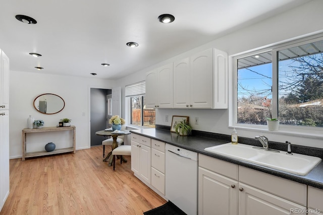 kitchen featuring dishwasher, sink, light hardwood / wood-style flooring, and white cabinets