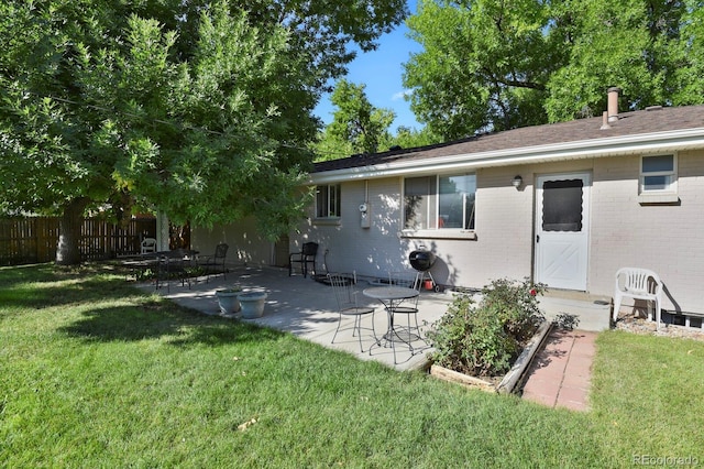 rear view of house with a yard and a patio