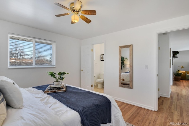 bedroom with ceiling fan, ensuite bath, and hardwood / wood-style flooring