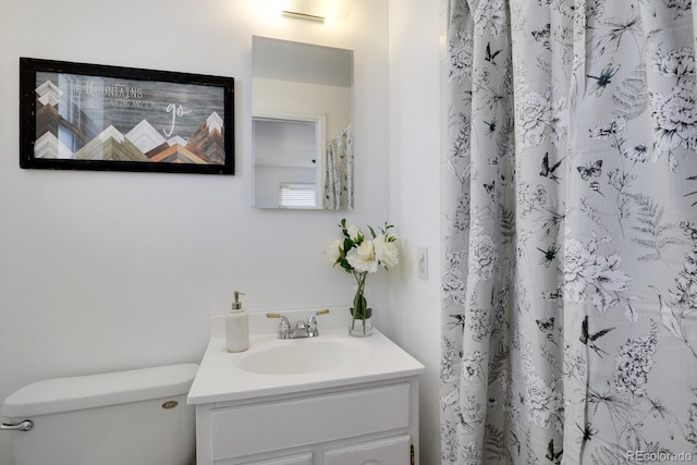 bathroom featuring a shower with curtain, vanity, and toilet