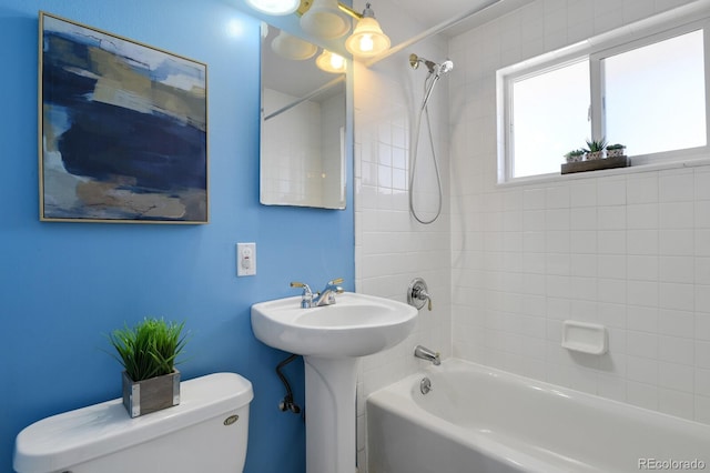 bathroom with tiled shower / bath combo and toilet