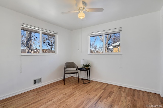 sitting room with ceiling fan and light wood-type flooring