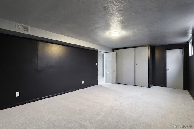 unfurnished bedroom with light colored carpet and a textured ceiling