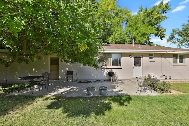 back of property with a yard and a patio area