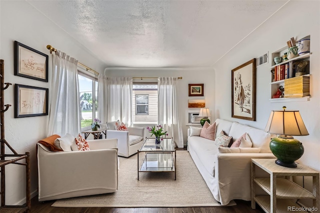 living area with wood finished floors and a textured ceiling
