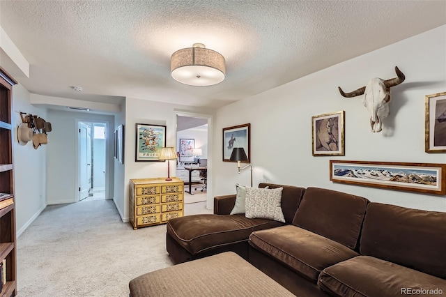 living area featuring light colored carpet, a textured ceiling, and baseboards