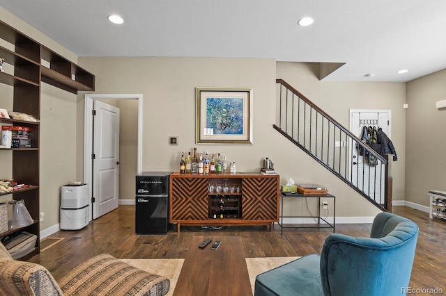 living room featuring bar and dark hardwood / wood-style flooring