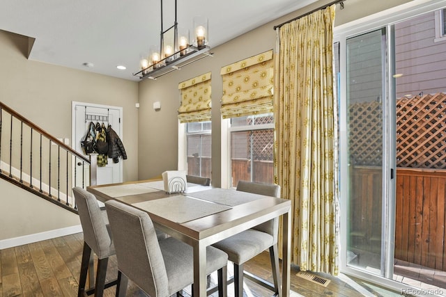 dining area with dark wood-type flooring and a chandelier