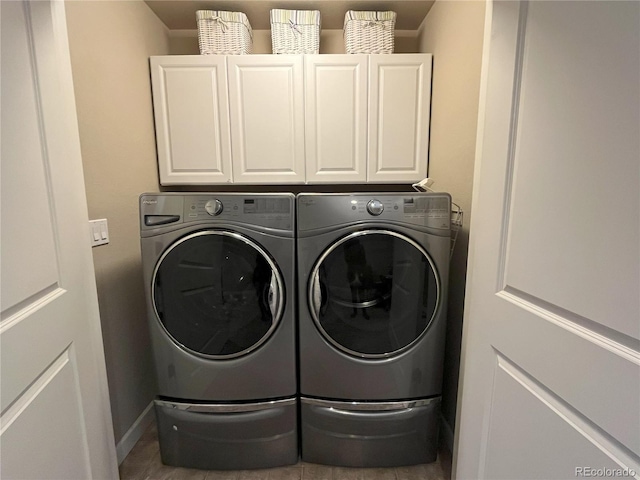 clothes washing area featuring independent washer and dryer and cabinets