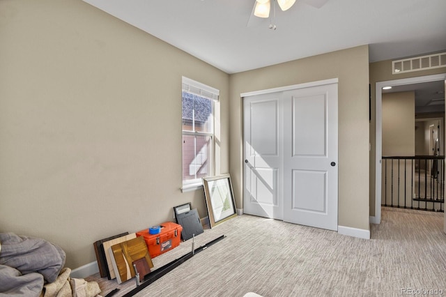 carpeted bedroom featuring ceiling fan and a closet