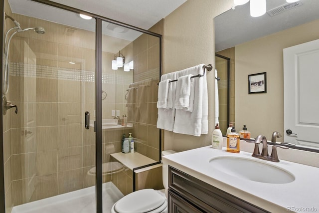 bathroom featuring vanity, toilet, and a shower with shower door