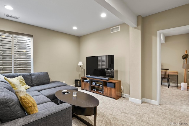 carpeted living room featuring beamed ceiling