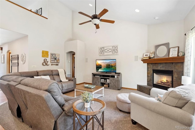 641 Denali Ct, Windsor, CO 80550 - living room featuring arched walkways, carpet floors, a glass covered fireplace, ceiling fan, and high vaulted ceiling