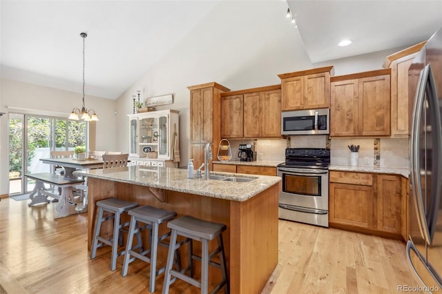 641 Denali Ct, Windsor, CO 80550 - kitchen with stainless steel appliances, a sink, a chandelier, tasteful backsplash, and light wood finished floors
