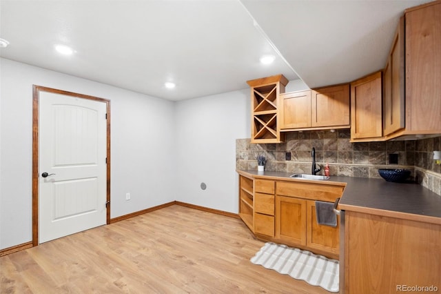 641 Denali Ct, Windsor, CO 80550 - kitchen with a sink, backsplash, light wood-style floors, dark countertops, and recessed lighting