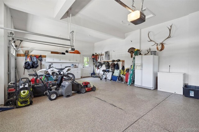 641 Denali Ct, Windsor, CO 80550 - garage featuring white refrigerator with ice dispenser, a garage door opener, and electric panel