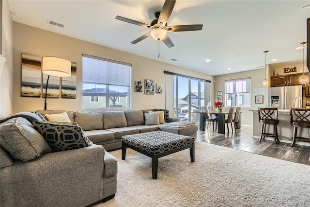 living room featuring ceiling fan and dark wood-type flooring