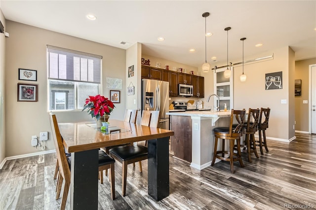 dining space with dark hardwood / wood-style floors and sink