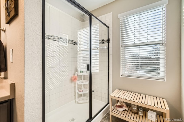 bathroom with an enclosed shower and a healthy amount of sunlight