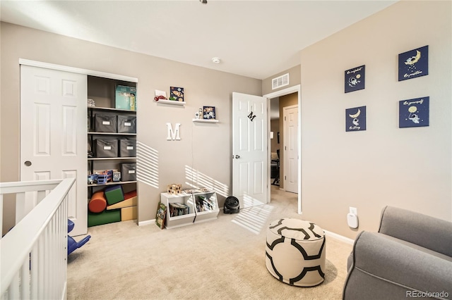 carpeted bedroom featuring a nursery area