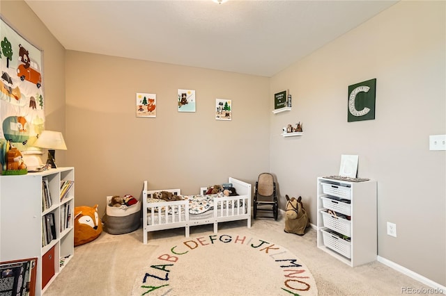 carpeted bedroom featuring a nursery area