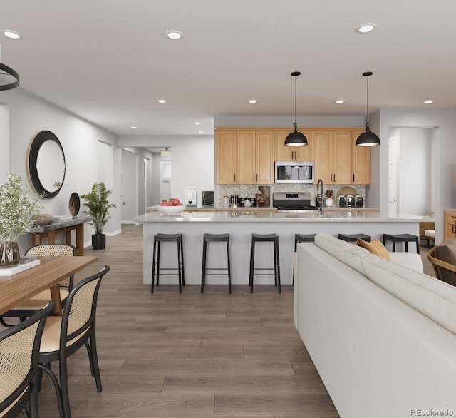 17055 W 92nd Loop, Arvada, CO 80007 - kitchen with stainless steel appliances, tasteful backsplash, a kitchen breakfast bar, light countertops, and recessed lighting