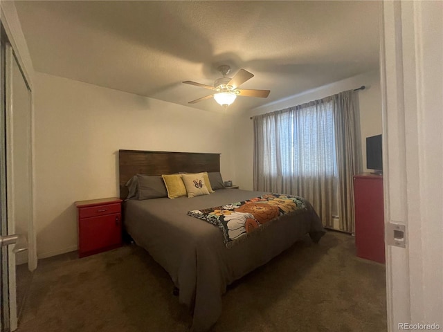 bedroom featuring dark colored carpet, ceiling fan, and a closet