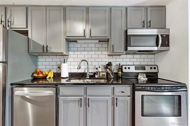 529 N Washington St Unit 304, Denver, CO 80203 - kitchen with stainless steel appliances, a sink, gray cabinets, tasteful backsplash, and dark stone countertops