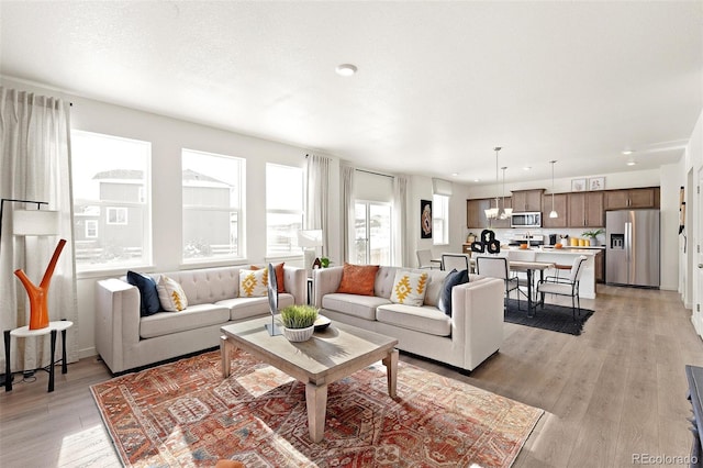 living room with light wood-type flooring and recessed lighting