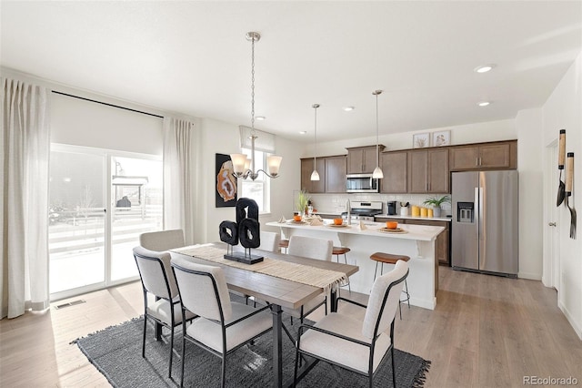 dining area with a chandelier, light wood-type flooring, and recessed lighting