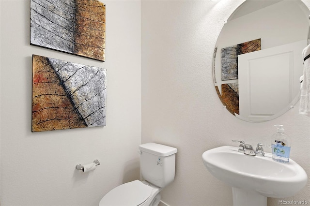 half bathroom featuring a sink and toilet
