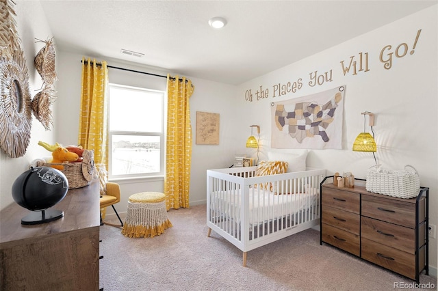 bedroom with a nursery area, carpet flooring, and baseboards