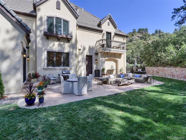 back of house featuring a lawn, outdoor lounge area, a patio, and a balcony