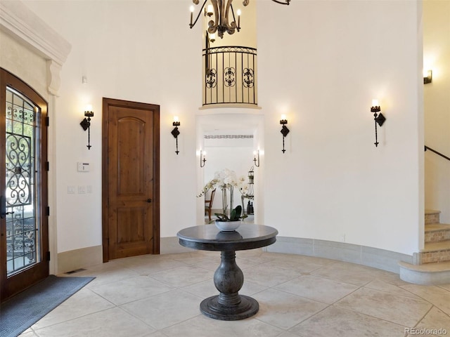 foyer with a towering ceiling, light tile patterned floors, and french doors