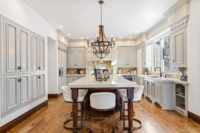 kitchen with sink, decorative light fixtures, a breakfast bar area, and a center island