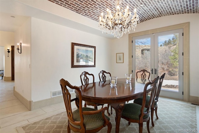 dining area featuring french doors, brick ceiling, vaulted ceiling, and a notable chandelier