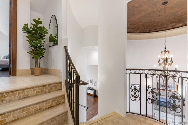 stairs featuring a notable chandelier