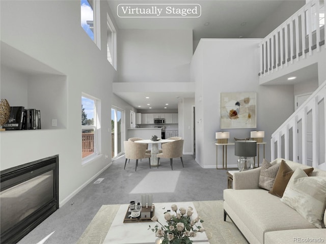 living room with carpet and a towering ceiling