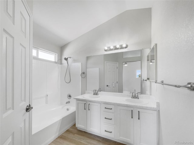 bathroom featuring washtub / shower combination, lofted ceiling, vanity, and hardwood / wood-style flooring