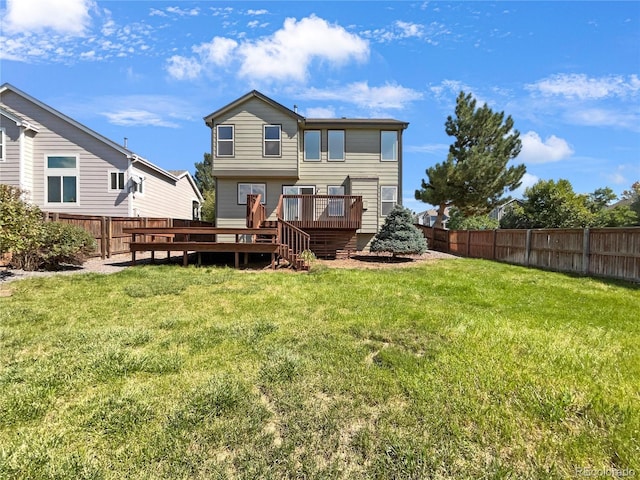 rear view of house with a lawn and a wooden deck