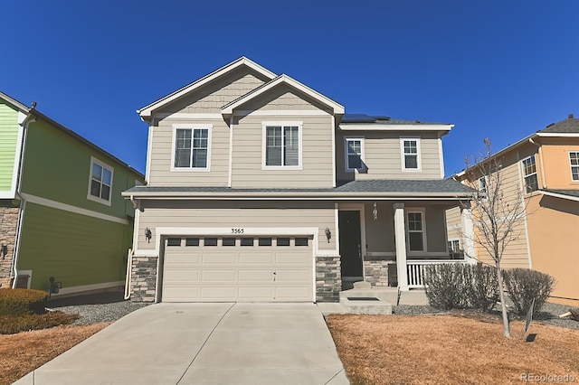 craftsman inspired home featuring stone siding, covered porch, driveway, and roof mounted solar panels